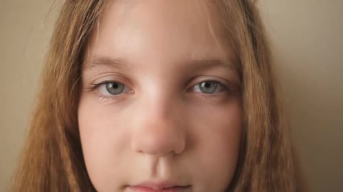 Close Up Female Face of Desperate Child Looking Into Camera Indoor