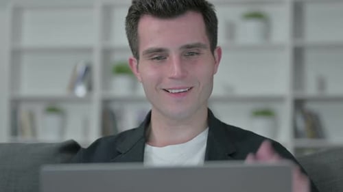 Man Video Conferencing on Laptop at Home