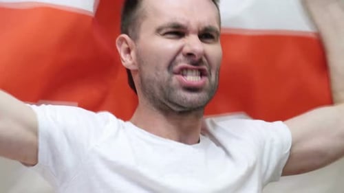Man Cheering and Yelling with Flag Raised Up