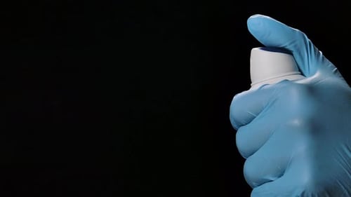 Spraying Fine Mist from Bottle with Gloved Hand