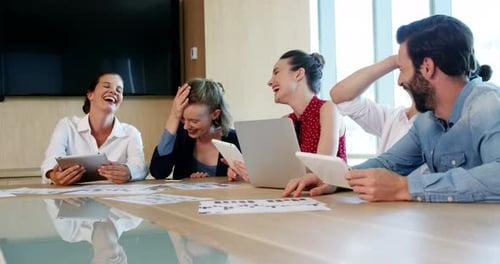 Five Colleagues Laughing Together During Meeting