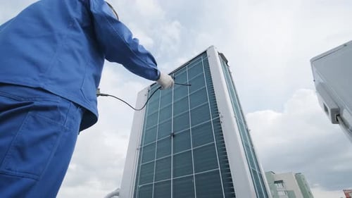 Technician Inspecting Air Conditioning Unit on Roof