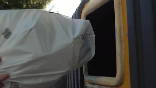 Hombre joven hombre dejando caer la botella de plástico de vidrio en la papelera de reciclaje y hay separación de residuos