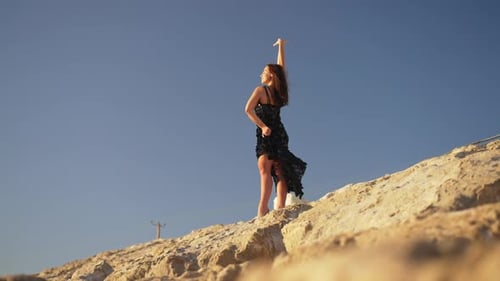 Wide Shot of Gorgeous Free Caucasian Ballet Dancer Standing on Yellow Rocky Coast with Clear Blue