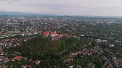 Aerial view of medieval castle on mountain in small european city at cloudy autumn day