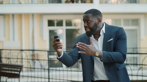Angry Businessman Having Video Chat at Urban Street