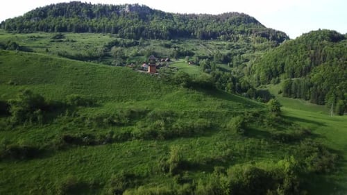 Aerial view.Christian bell tower on a hill in spring nature. Forged cross on the roof.