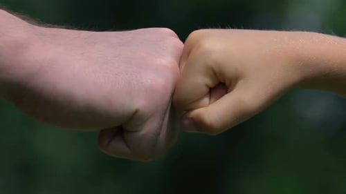 Fist Bump d'un homme adulte et d'un petit garçon en gros plan