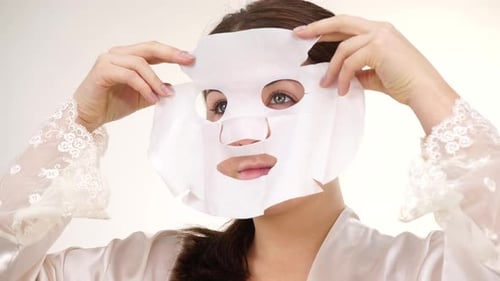 Woman Applying Sheet Mask on Face