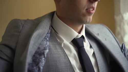 Man Puts on Gray Suit Jacket Inside Home