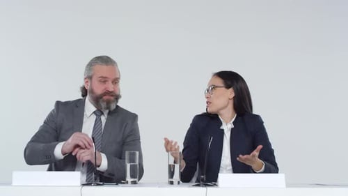 Professionals Speaking at Conference Table with Microphones