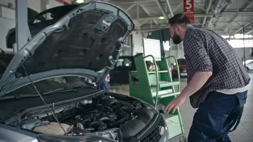 Mechanic Diagnosing Car Engine in Auto Repair Shop