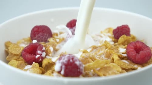 Cornflakes and Raspberries with Milk Pouring