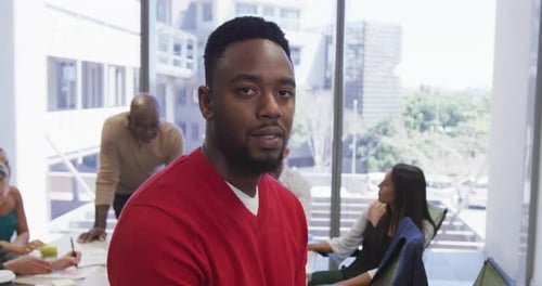 Smiling Man in Meeting with Diverse Colleagues