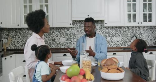 Family of Four Eating Breakfast Together at Home