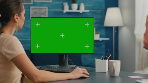 Woman Looking at Computer with Green Screen Mock Up Chroma Key Display