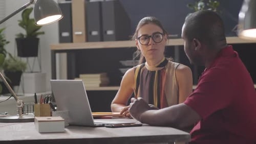 Colleagues Collaborate on Laptop in Modern Office