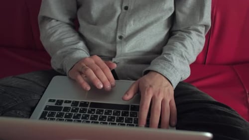 Young Adult Types on Laptop on Couch