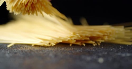 Pasta Falling on Dark Surface