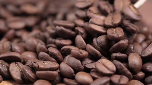 Nahaufnahme von frischen Kaffeebohnen auf schwarzem Hintergrund