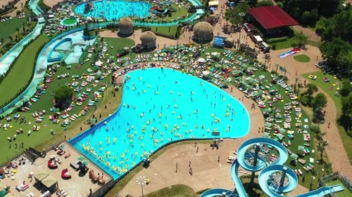 Blick von oben auf Menschen, die sich im Pool auf gelben aufblasbaren Kreisen entspannen