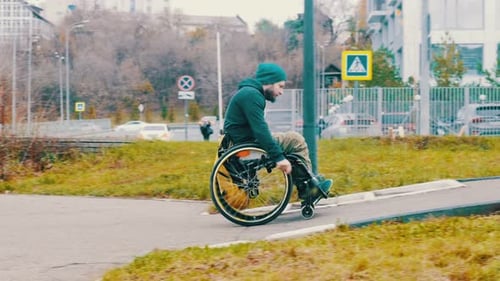 Disabled Man in Wheelchair Makes Attempt To Steer His Wheelchair Over a Ramp on the Street
