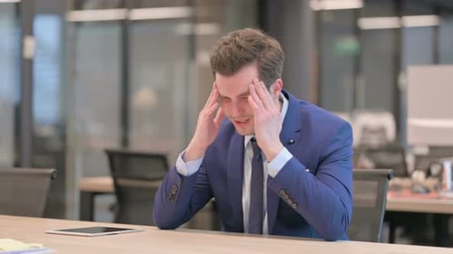Sleepy Businessmanhaving Headache While Sitting in Office