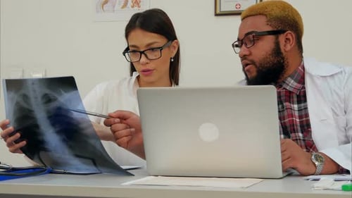 Doctors Reviewing X-Ray in Bright Office Setting
