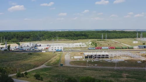 Zona industrial com trem de carga em uma ferrovia.