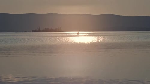 Lone Kayaker Paddling on Lake at Sunset