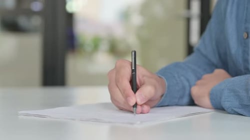 Close Up of Man Writing on Paper