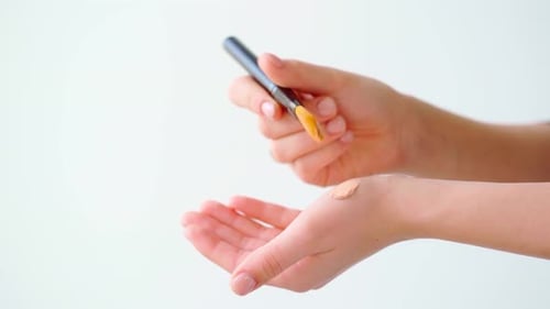 Female Testing the Tone of Make Up Foundation Close Up