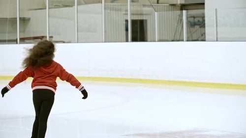 Girl Ice Skating Skillfully in Indoor Rink