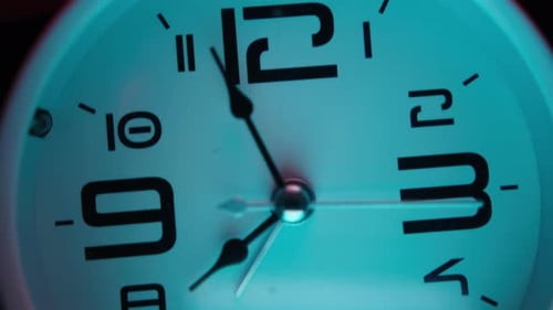 White alarm clock in pink and cyan abstract colors. Close-up, alarm clock concept