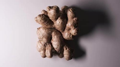 Low Key Light Raw Ginger Rotate or Spin on White Background Top Down View