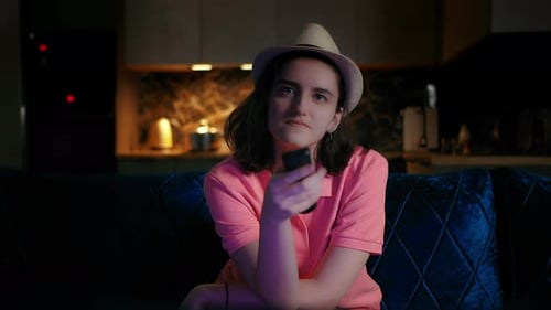 Woman Sits on Couch Watching Television At Night