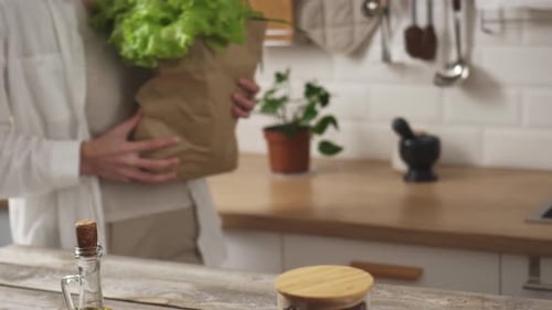 Una joven madre trajo una bolsa de papel con verduras ecológicas para una alimentación saludable