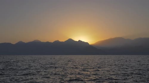 Beautiful Sunset Over Sea and Distant Mountains