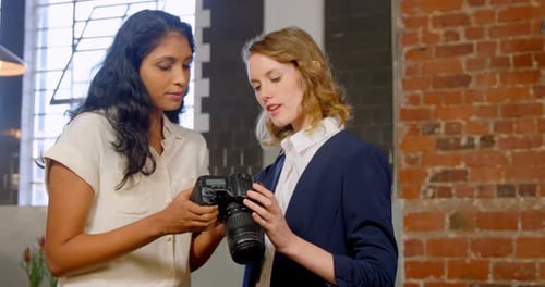 Women Collaborating on Photography Project in Urban Office