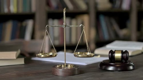 Nahaufnahme von Gavel und Goldmessing-Waage auf dem Richtertisch