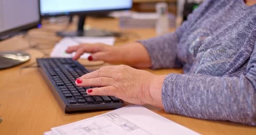 Hands Typing on a Keyboard in an Office