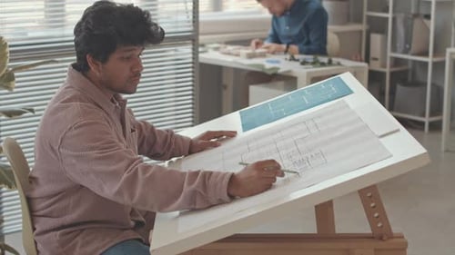 Biracial Architect Drawing Blueprint in Office