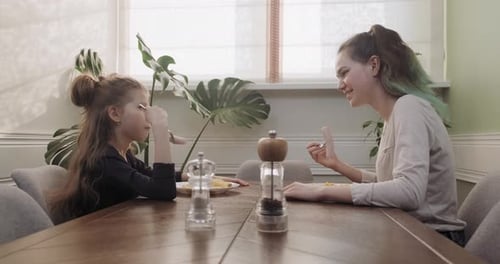 Girl and Teen Enjoying Lunch Together at Home
