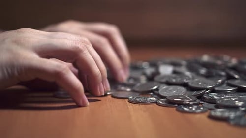 Hands Interacting with Pile of Coins, Close-Up