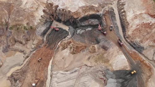 Cantera de arcilla o calx a cielo abierto con muchos camiones de maquinaria, vista aérea desde arriba