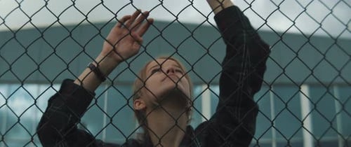 Young Woman Holding Chain Link Fence Outdoors