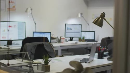 Interior of empty modern office with desks, chairs, laptops and computers
