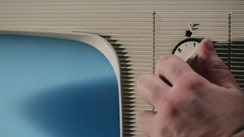 Hand Turning Channel on Vintage Television Set