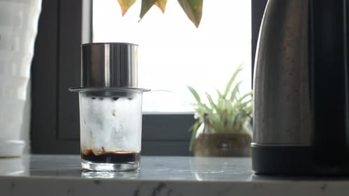 Coffee Drips Slowly From Press Into Glass