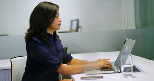 Businesswoman using laptop in office 4k
